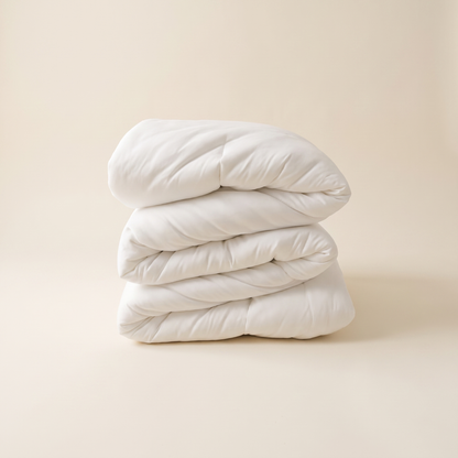 The Meringue Comforter folded in a stack — plush double-stuffed volume